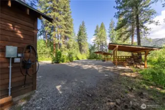 EV charger and Wood shed with covered storage for firewood and tools.