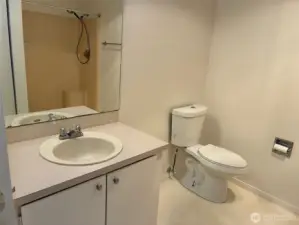 Large bathroom with walk in shower, second closet and storage shelves.