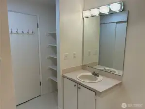 Large bathroom with walk in shower, second closet and storage shelves.