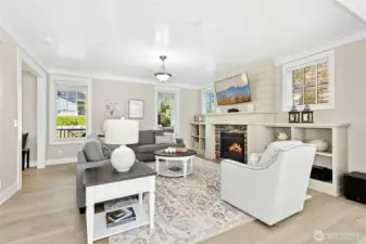 A bright, comfortable living room filled with natural light features a cozy fireplace and built-in shelves.