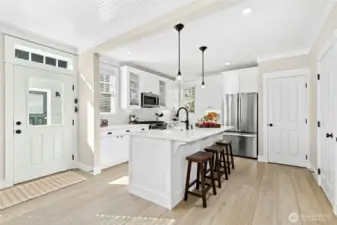 A sunny kitchen with an airy feel - the island and counter seating make it the perfect gathering spot after a day at the beach. Stainless appliances and a roomy pantry keep everything neat and easy.