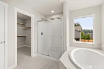 Walk-in shower features a bench and sliding glass door