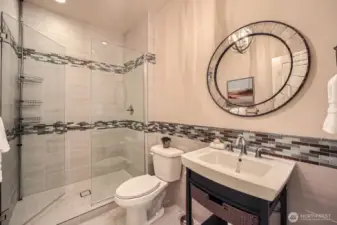 Bathroom 3, located on the main level, features a designer-tiled shower, custom vanity, and stylish designer lighting for a refined, modern touch.