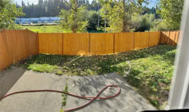 Fully fenced back yard has sunny western exposure