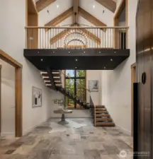 Rustic steel mono-stringer with solid 4” thick white oak treads. Defies logic and gravity  due to the mass and floating affect. The tall stair tower window is all tempered glass for  safety when on the stairs.