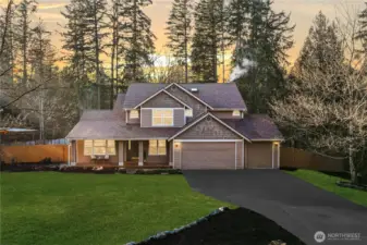 Front exterior of a Maple Valley home for sale with covered porch, mature trees, and private setting in the Tahoma School District.