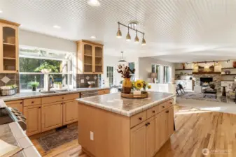 Open-concept kitchen in this Maple Valley home featuring an oversized island, warm wood cabinetry, and hardwood floors.