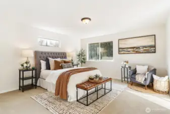 Spacious primary bedroom with plush carpet, calming tones, and room for seating.