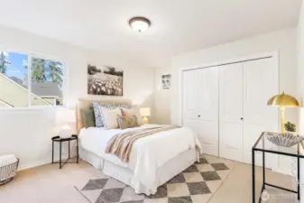 Well-sized bedroom with large window and comfortable living space.