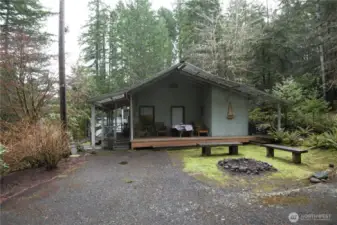 Firepit and side of home with covered wood deck
