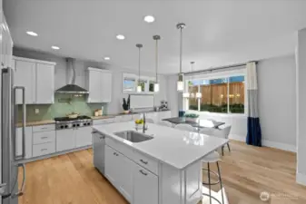 Step into this gorgeous kitchen with a large island, quartz counters, full height cabinets and pendant lighting. The gas range with pot filler make cooking a joy!