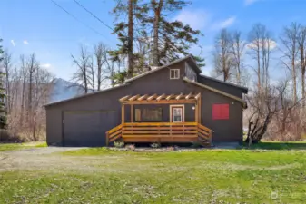 Enjoy the front porch while looking over the lush green acreage.