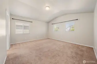 Very large primary suite with windows facing the front and side of the home.