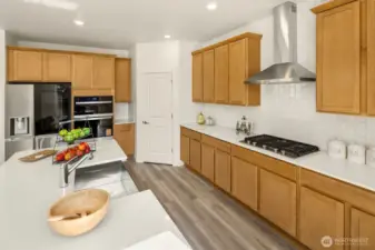 This gourmet kitchen has a gas cooktop with hood vent, Quartz counter tops, tiled backsplash, a nice walk-in corner pantry closet. Big island with deep stainless steel sink & breakfast bar