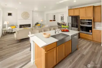 The big island with deep stainless steel sink, dishwasher, and Quartz counters