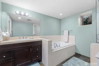 Primary bathroom with soaking tub, surrounded by travertine tiles on exposed surfaces.