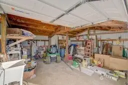 Garage off house has  utity sink and cabinets for storage.