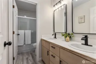 Upper hallway bath with refreshed floors. hardware and mirror and lighting