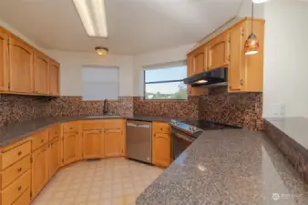 Large kitchen with granite counter tops, tile backsplash, new range/oven & dishwasher. Tons of storage.