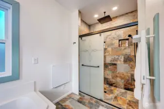 Large, tiled walk-in shower with removable shower head/sprayer and overhead rain shower head.