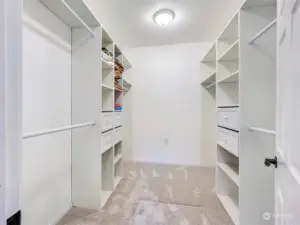 Walk-in closet with built in shelving and drawers.