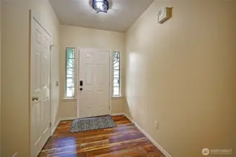 Entry way features a coat closet & custom door with side lights.