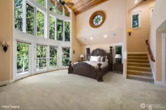 Dramatic two story Primary Bedroom. Bow to Bay wall of windows called the Wedding Cake.
