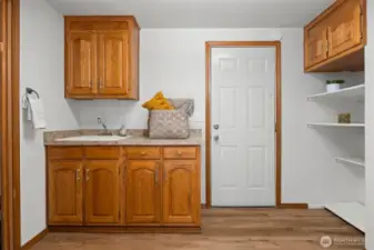 Spacious laundry room with plenty of storage and a sink. Door leads to oversized one car garage.