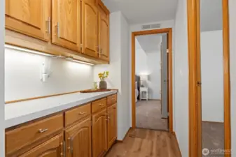 Wide hallway with NEW luxury vinyl plank flooring and built in storage leads to all three bedrooms.