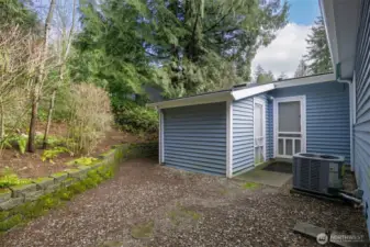 Backyard of home. Storage shed on left. Back door to garage on right.