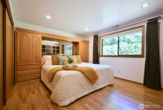 Primary bedroom with Solid oak built ins for King bed for storage, along with closet space. Room Measures 14 x 14   with custom window blinds.