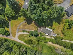 This aerial perspective showcases the home, covered deck, and shy acre—peaceful, private, and full of potential.