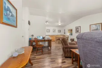 The entry offers a warm welcome with sightlines into the open living and dining spaces, highlighted by fresh new flooring and stunning hickory cabinets.