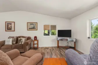 The living room offers vaulted ceilings, beautiful light, and scenic views—perfect for relaxing or entertaining.