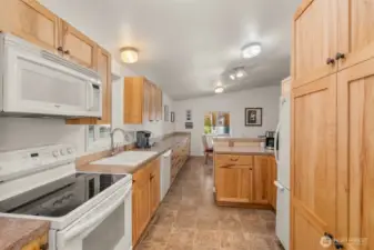 Custom kitchen with rich hickory cabinets with pantry storage and oversized drawers—designed for both beauty and function.