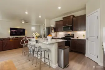 This kitchen is designed with both elegance and efficiency in mind. The expansive island serves as a centerpiece, ideal for meal prep or casual dining, while the under-cabinet lighting adds a sophisticated touch, enhancing visibility and ambiance. A large walk-in pantry offers generous storage, keeping your kitchen clutter-free. Flowing directly into the open living area, this kitchen is perfect for hosting and everyday life.