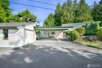 Looking towards front door. Covered carport, and detached garage/workshop to the left.