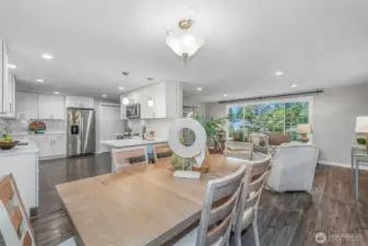 The open layout creates a seamless connection between the kitchen, dining, and living areas. This central hub of the home is perfect for entertaining or enjoying everyday life in a light-filled setting.
