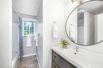 The full main bath features a modern vanity, updated fixtures, and a tub/shower combination. A bright window keeps the space light and fresh.