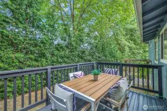 Step outside to the private back deck surrounded by tall evergreens. This outdoor space is ideal for dining, entertaining, or simply enjoying the quiet setting.