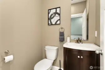 Stylish main-floor powder room features a rich wood vanity and sleek modern fixtures.