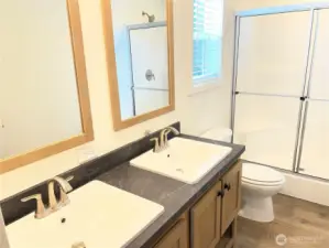 Primary bathroom with double vanities and walk in shower.