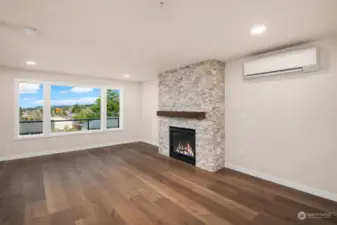 Living room area features a stacked travertine stone surrounds the gas fireplace. TV hookup in center.