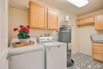 Spacious laundry room has built in cabinets and space for freezer