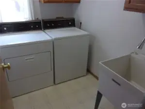 Laundry room includes washer, dryer, and utility tub.