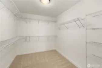 Primary Walk-In Closet: Oversized walk-in closet includes extensive shelving and hanging space. Designed for organization, it keeps everything within easy reach while maximizing storage.    Photos are from a previous Glacier model home at Foxmoore and are for visualization purposes only - colors, selections, and included feature can and will vary.