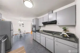 Kitchen with new granite countertops and freshly painted cabinets and new flooring.