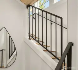 Custom metal handrails lead up solid wood stairs to the upper level.