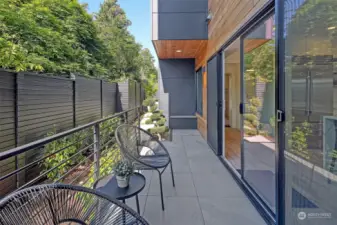 Private deck of kitchen leads to a fully fenced backyard.
