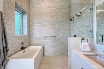 Spa-like primary bath with soaking tub, double sinks, large walk-in shower, and heated floors